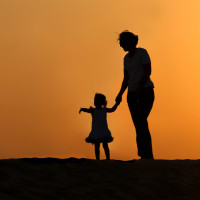 Silhouette of people in front of burning sky in desert