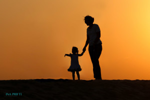 Silhouette of people in front of burning sky in desert