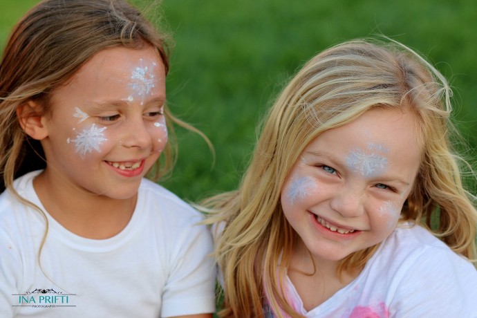 Big smiles on two friends with faces painted