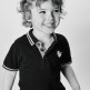 Curly-haired boy with cheeky smile in black and white portrait shot